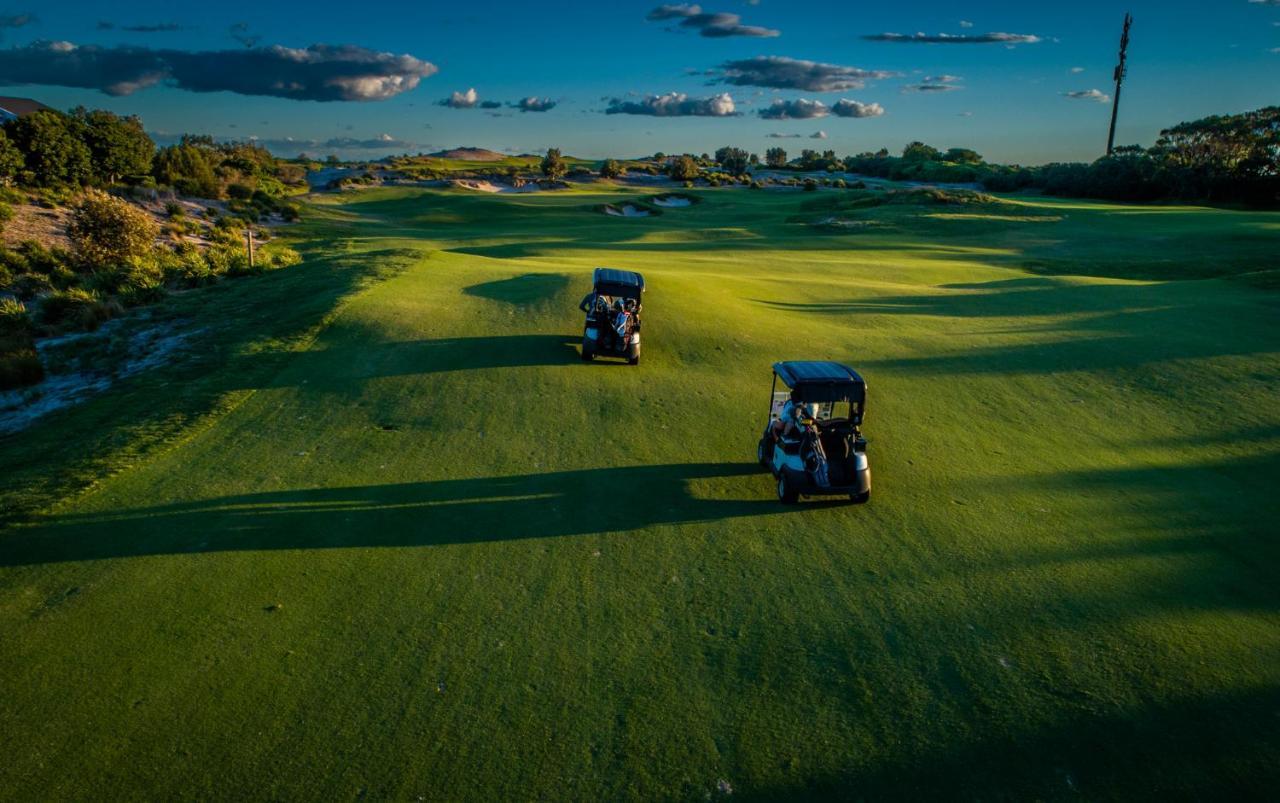 Pullman Magenta Shores Resort Entrance Eksteriør billede Golf carts on the green